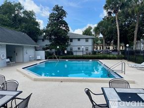 Ocala condo for rent - A pool surrounded by chairs and tables is available for use.
