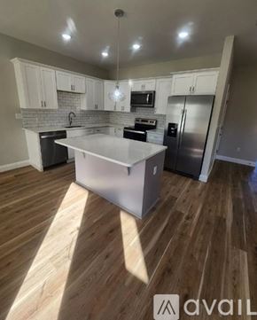 Defuniak Springs townhouse for rent - A kitchen with wooden floors and white cabinets.