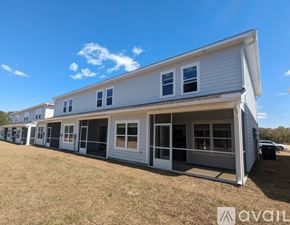 Defuniak Springs townhouse for rent - A white mobile home with a porch and multiple windows.