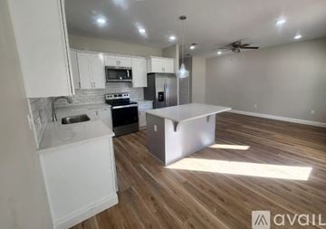Defuniak Springs townhouse for rent - A kitchen with white cabinets and a wooden floor.