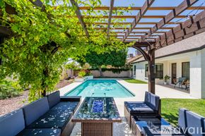 Glendale house for rent - A pool with a table and chairs under a pergola.