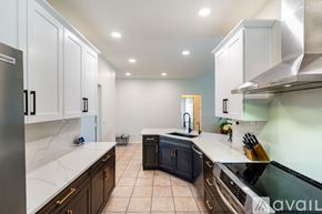 Glendale house for rent - A kitchen with black cabinets and a white countertop.