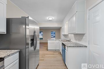 Waco house for rent - A kitchen with a refrigerator on the left and cabinets on the right.