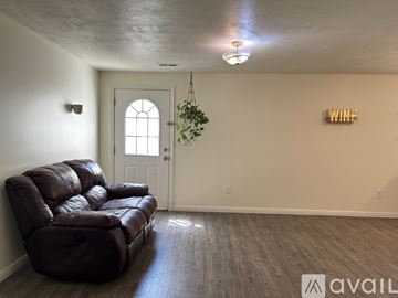 Salt Lake City house for rent - A living room with a brown leather sofa and a hanging plant.