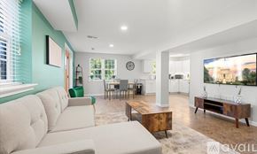 Alexandria apartment for rent - A living room with a large couch and a television on the wall.