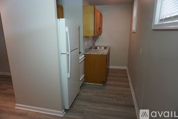 Baltimore apartment for rent - A kitchen with a white refrigerator and wooden cabinets.