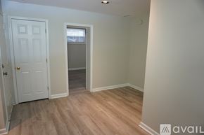 Baltimore apartment for rent - A room with a white door and wooden flooring.