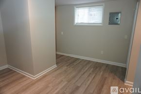 Baltimore apartment for rent - A room with wooden flooring and a window with blinds.