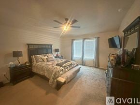 San Antonio house for rent - A bedroom with a large bed and a ceiling fan.