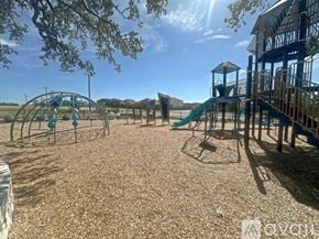 San Antonio house for rent - A playground with a green slide and a wooden structure.