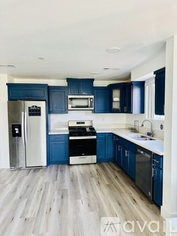 Los Angeles townhouse for rent - A kitchen with blue cabinets and a white refrigerator.