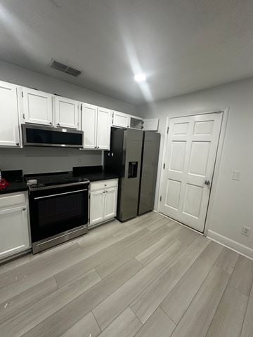 Jacksonville house for rent - A kitchen with white cabinets and a refrigerator.