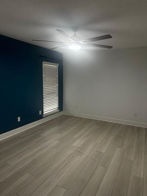 Jacksonville house for rent - A room with a ceiling fan and wooden flooring.