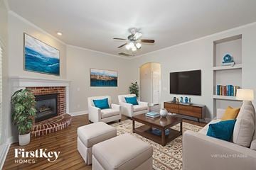 Edmond house for rent - A living room with a fireplace and a painting of a beach scene on the wall.