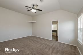 Edmond house for rent - A spacious room with a carpeted floor and a ceiling fan.