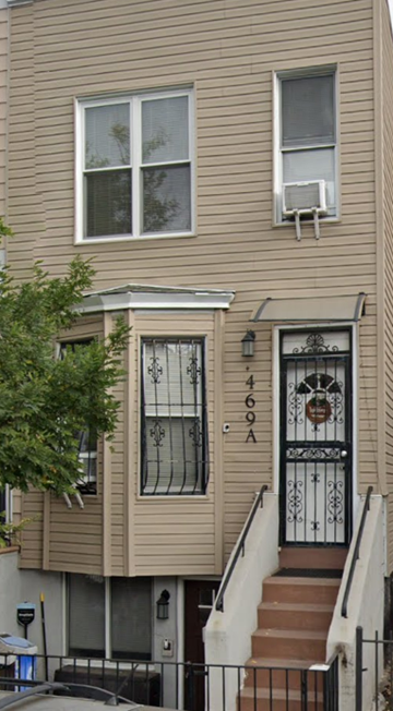 Brooklyn apartment for rent - A two story house with a black gate and a white door.