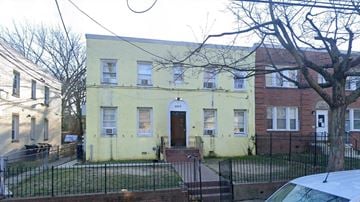 Washington apartment for rent - A yellow house with a black fence in front.