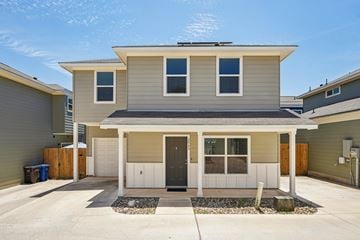 San Antonio house for rent - A house with a grey roof and white walls with a black mat in front.