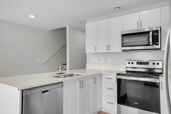 Saskatoon apartment for rent - A modern kitchen with white cabinets and stainless steel appliances.