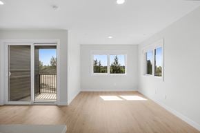Saskatoon apartment for rent - A spacious room with wooden floors and three windows.