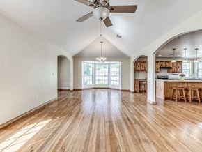 Harrah house for rent - A spacious room with wooden floors and a ceiling fan.