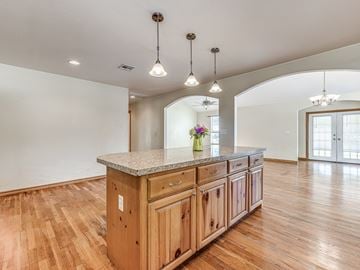 Harrah house for rent - A kitchen with wooden cabinets and a granite countertop.