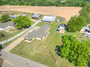 Harrah house for rent - A rural landscape with a few buildings and trees.