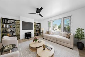 San Diego apartment for rent - A living room with a white couch, a coffee table, and a fireplace.
