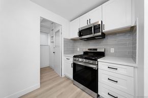 San Diego apartment for rent - A kitchen with white cabinets and a black oven.
