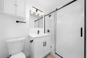 San Diego apartment for rent - A white bathroom with a toilet, sink, and mirror.