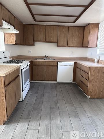 Apple Valley apartment for rent - A kitchen with wooden cabinets and a white stove top oven.