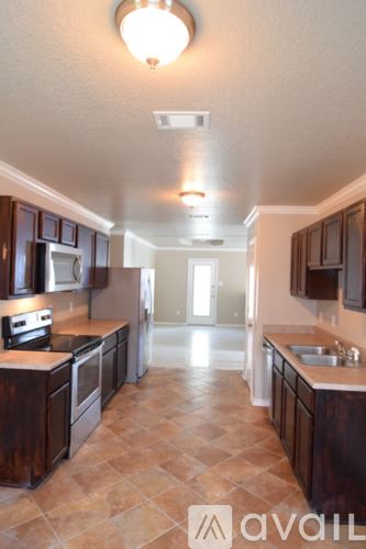 Belton house for rent - A kitchen with brown cabinets and a tile floor.
