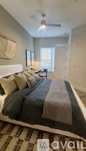 Tampa apartment for rent - A bedroom with a bed in the center and a window with blinds on the right side.