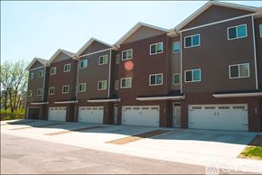 North Mankato townhouse for rent - Apartment building with brown and grey exterior and white garage doors.