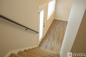North Mankato townhouse for rent - A staircase with a carpeted runner and wooden steps leading to a door.
