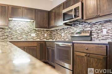 North Mankato townhouse for rent - A kitchen with wooden cabinets and a stone backsplash.