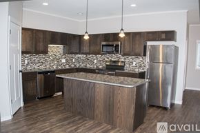 North Mankato townhouse for rent - A kitchen with wooden cabinets and a stone backsplash.