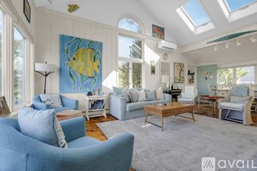 York house for rent - A living room with a blue couch and a painting of a yellow fish on the wall.