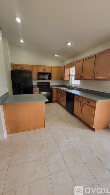 Ocala house for rent - A kitchen with wooden cabinets and black appliances.