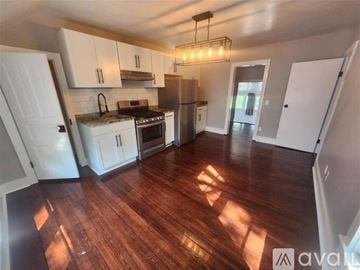 Petoskey apartment for rent - A kitchen with white cabinets and a wooden floor.
