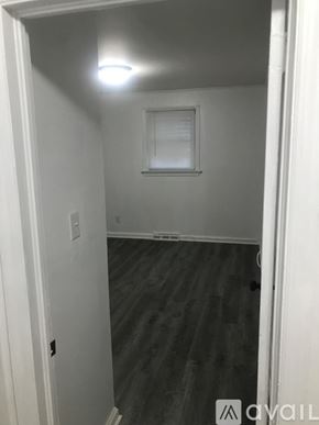 Kinston house for rent - A room with a wooden floor and a window with blinds.