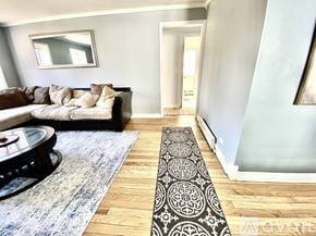 Evanston apartment for rent - A living room with a black and white couch, a glass table, and a television.