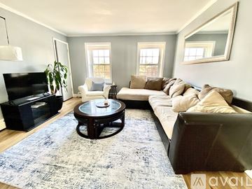 Evanston apartment for rent - A living room with a white chair and a black ottoman.