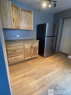 Evanston apartment for rent - A kitchen with wooden cabinets and a stainless steel refrigerator.