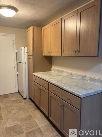 Manchester apartment for rent - A kitchen with white appliances and brown cabinets.