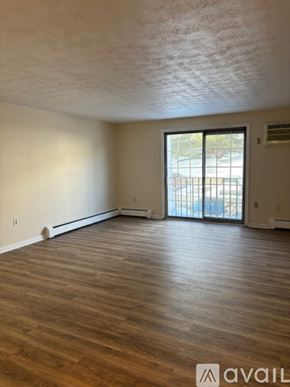 Manchester apartment for rent - A bathroom with a toilet, tub, and window.