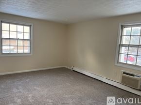 Manchester apartment for rent - A room with a carpeted floor and a window with blinds.