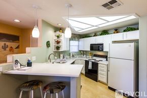 Phoenix condo for rent - A kitchen with a white counter and a white fridge.