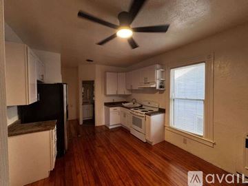 Sacramento house for rent - A kitchen with white cabinets and a black refrigerator.