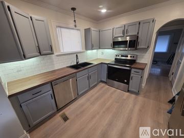 St. Louis house for rent - A kitchen with wooden floors and grey cabinets.